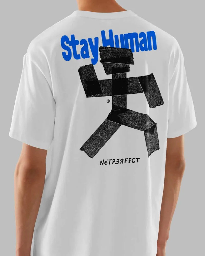 Playera blanca vista de espalda: Stay Human en azul y el Stickman hecho de cinta negra.